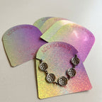 Tarjeta holográfica porta joyas con una pulsera puesta, junto a otras tarjetas en abanico
